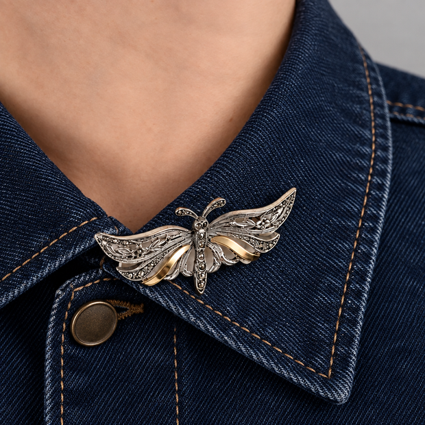 Broche de mariposa en el cuello de una chaqueta de jean